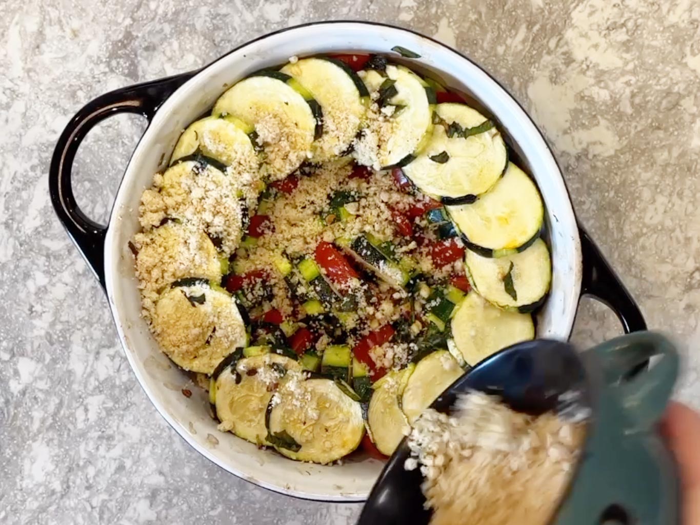 Sprinkling crumb topping on tomato courgette bake