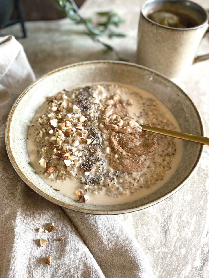 Bowl of coconut milk oatmeal with a cup of tea