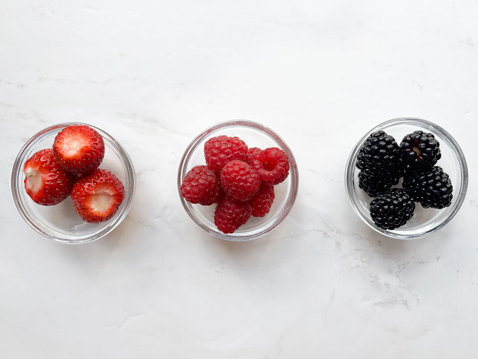 Bowls of strawberries raspberries and blackberries
